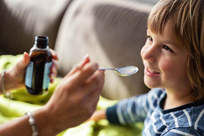 little boy taking a spoonful of medicine 