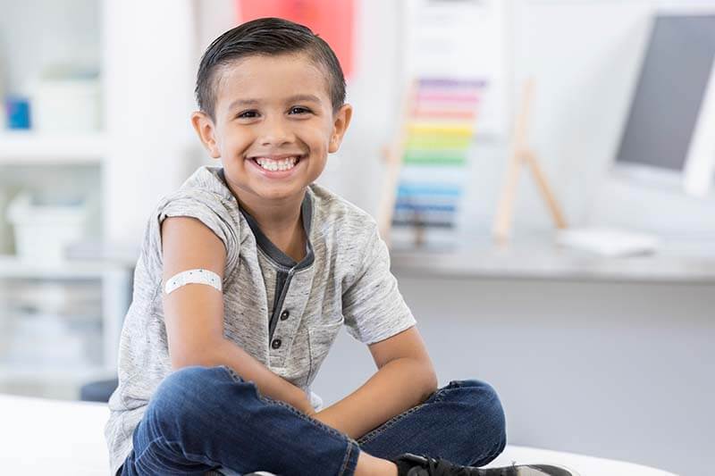 young boy smiling at the pediatrician's office 